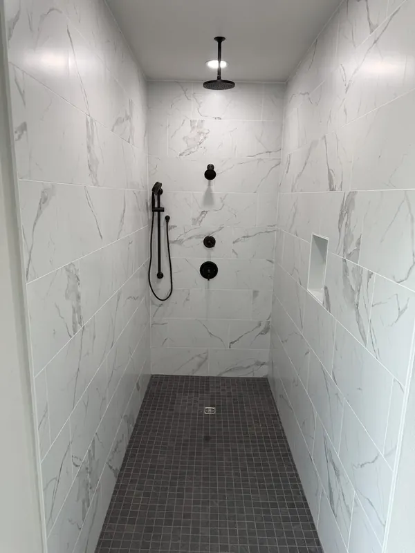 Custom walk-in shower with marble tile and matte-black fixtures