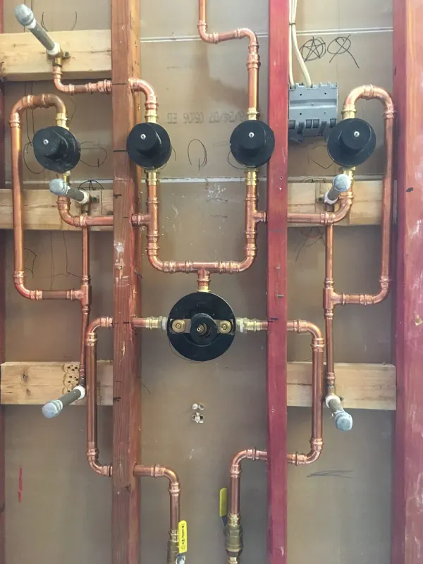 Copper supply manifold with shutoff valves roughed in between wall studs