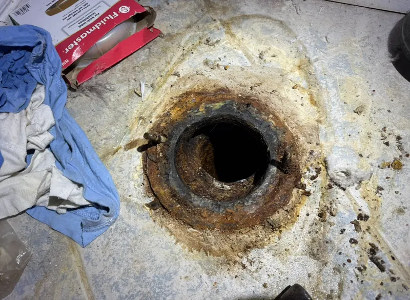 Badly corroded toilet flange exposed during a service call before replacement