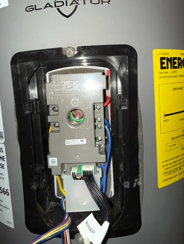 Thermostat and wiring panel opened on a new smart water heater during hookup