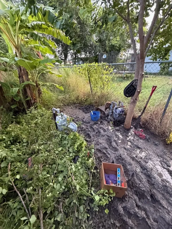 Water meter and shutoff valves exposed in a dug-out yard during service line work