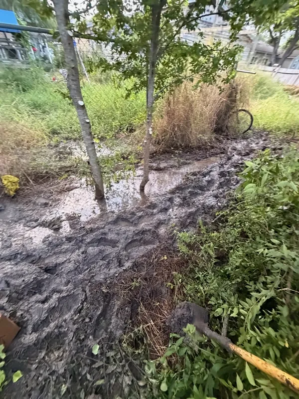 Muddy backyard excavation locating the source of an underground water leak